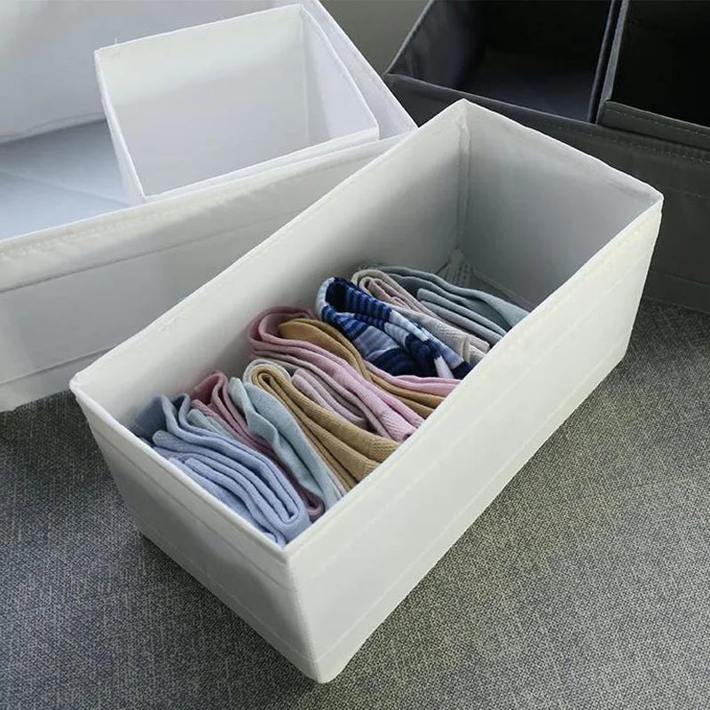 The OWOW Me Large foldable clothes organizer in white neatly holds pastel socks in two rows within its compartments, displayed on a gray textured surface.